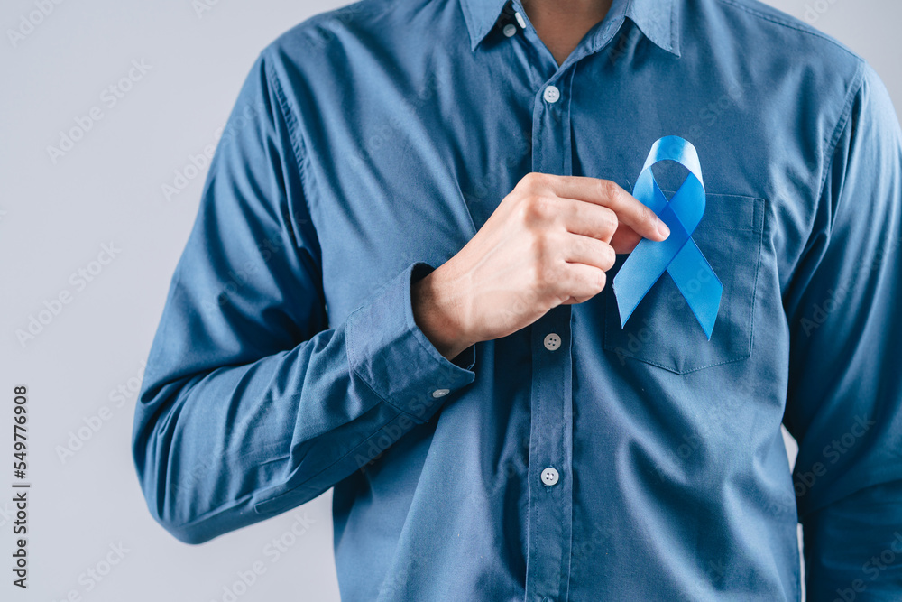 men hands holding Blue ribbon for supporting people living and illness, Colon cancer, Colorectal cancer, Child Abuse awareness, world diabetes day, International Men's Day men hands holding Blue ribbon for supporting people living and illness, Colon cancer, Colorectal cancer, Child Abuse awareness, world diabetes day, International Men's Day