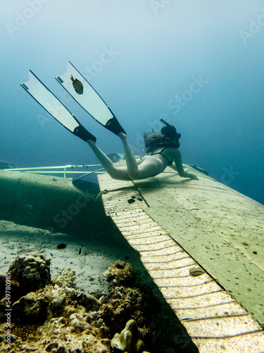 Young female poses on a plane wreck without the help of a breathing apparatus.
