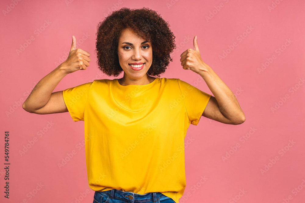 Young African American black woman isolated on pink background giving a thumbs up gesture. Young African American black woman isolated on pink background giving a thumbs up gesture.