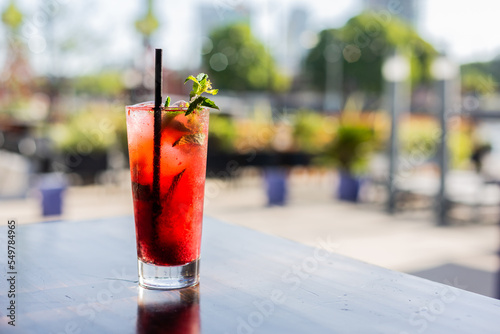 Red Fruit Mojito cocktail on the table. Cranberry mojito cocktail with cranberry, ron, lime and sugar. Delicious icy drink for holiday. photo