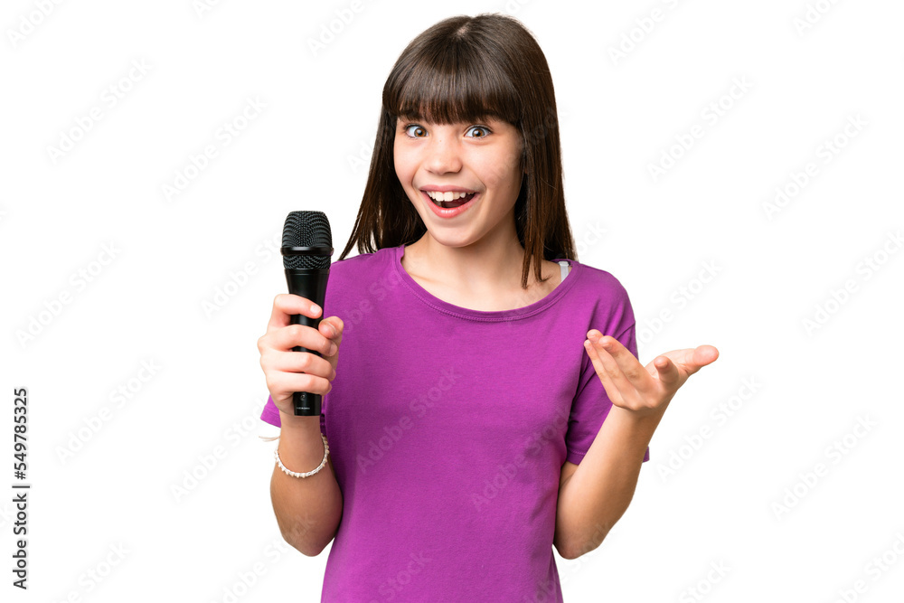 Little singer girl picking up a microphone over isolated background
