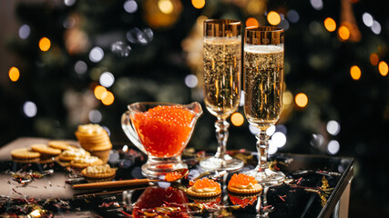 Elegant glass of champagne with red caviar on golden spoon and glass container of caviar, Gourmet food close up, appetizer, selective focus, place for text