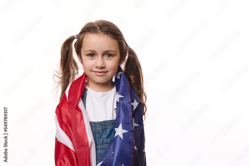 Isolated portrait on white background of beautiful American little girl with USA flag. Citizenship, immigration, emigration, winning the green card lottery and freedom concept. Independence Day July 4 Isolated portrait on white background of beautiful American little girl with USA flag. Citizenship, immigration, emigration, winning the green card lottery and freedom concept. Independence Day July 4