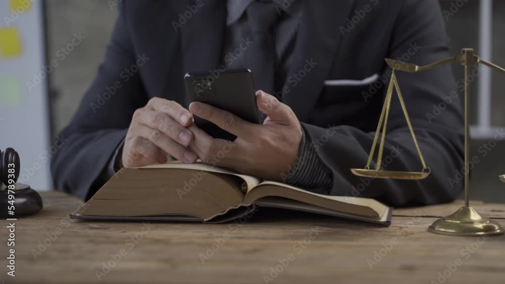 Lawyer office concept of online legal advice and legal advice. Lawyer Judge Sitting At Table With Paper Smartphone And Hammer Golden Scales Of Justice 4K Lawyer office concept of online legal advice and legal advice. Lawyer Judge Sitting At Table With Paper Smartphone And Hammer Golden Scales Of Justice 4K