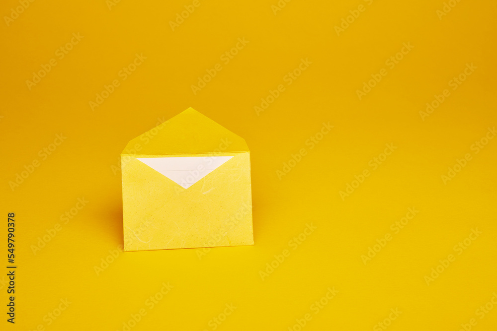 Yellow color paper office envelope with white lined sheet with copy space isolated on the bright solid fond plain yellow background - obrazy, fototapety, plakaty 