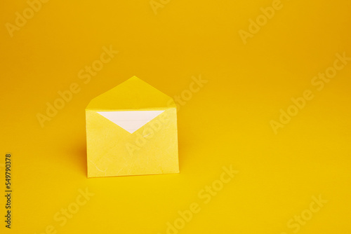 Yellow color paper office envelope with white lined sheet with copy space isolated on the bright solid fond plain yellow background