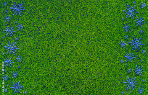 Winter green saturated bright background with white snowflakes on two sides.