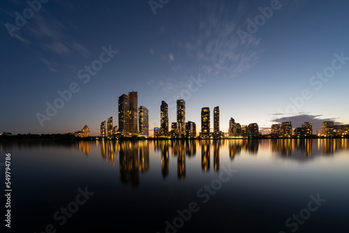 Night cityscape of buildings, towers, skyscrapers with beautiful colorful electric lights reflection in still water surface. Long exposure shot. Toronto, Canada. Space for copy. Condo market concept.