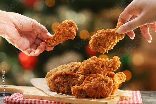 People hands taking the fried chicken wings by hands,Christmas night dinner. photo