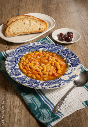 Homemade bean soup with vegetables . Greek bean soup with tomatoes, carrots, celery, and onions. Fasolada
