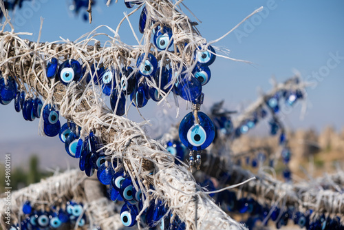 many traditional turkish Evil Eye Bead Amulets on the tree nazar boncuk from blue glass souvenir photo