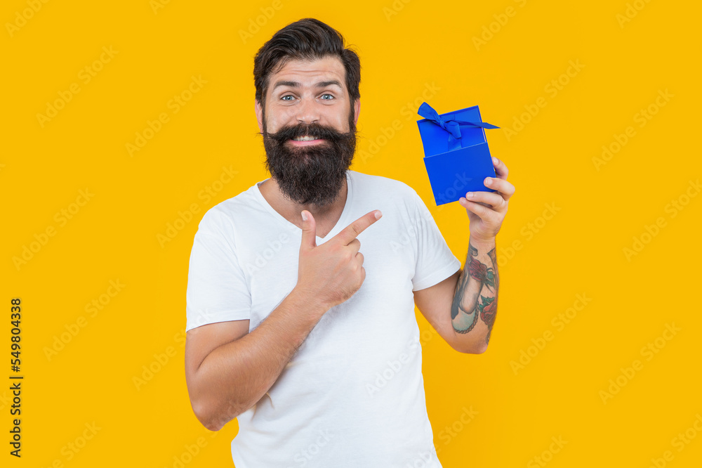 present box for guy in shirt. birthday guy point finger on present box. bearded guy with present box present box for guy in shirt. birthday guy point finger on present box. bearded guy with present box