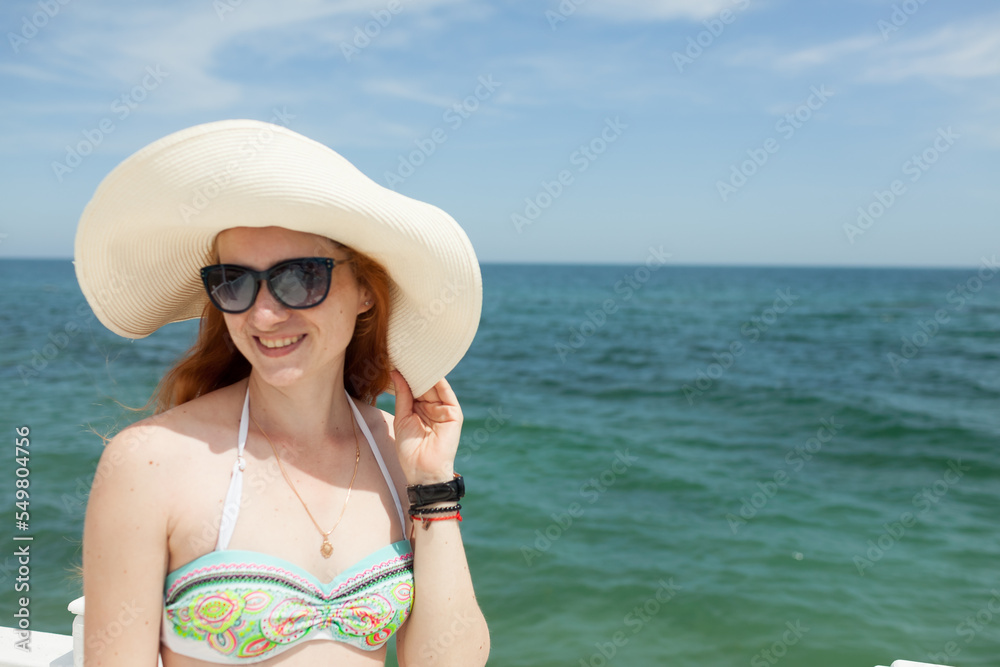 young red-haired girl in a hat on the background of the sea young red-haired girl in a hat on the background of the sea