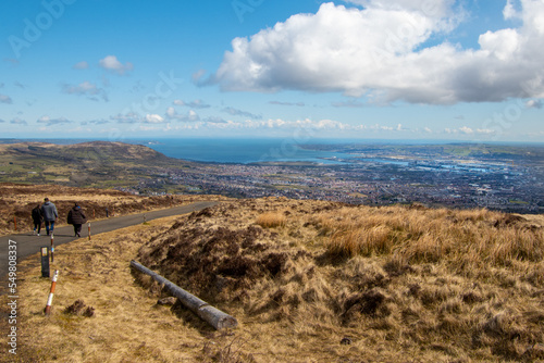 View of Belfast city from the top of Divis and The Black Mountain. People walking along the path down the hill. Belfast, Norther Ireland, UK