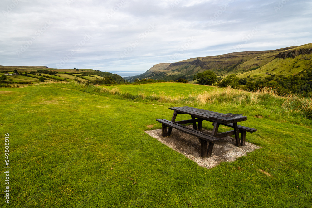 Picnic table at Glenariff forest park, see and mountains on the background. Northern Ireland. Picnic table at Glenariff forest park, see and mountains on the background. Northern Ireland.