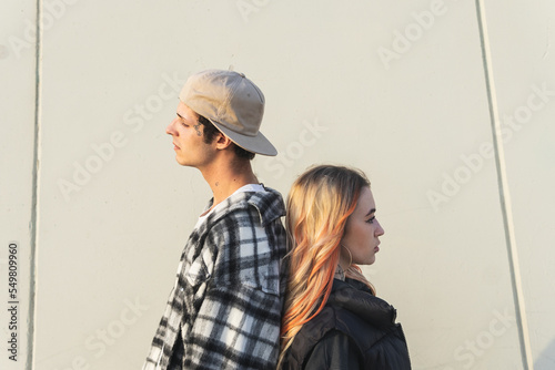 Young couple standing back to back photo