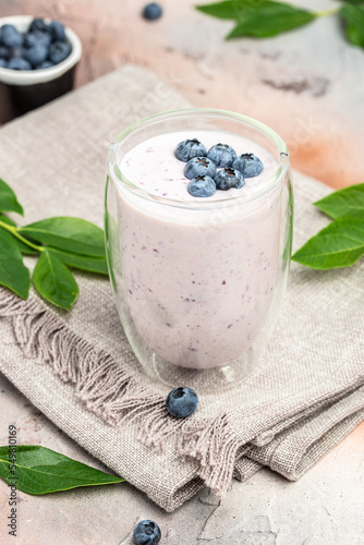 Blueberry jogurt, Tasty blueberry smoothie in glass on a light background, vertical image. place for text photo