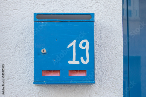 Blue Spanish mailbox on the facade of a rural house