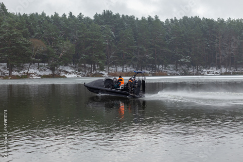 A rescue team is sailing on a hovercraft to rescue fishermen on the ice.
