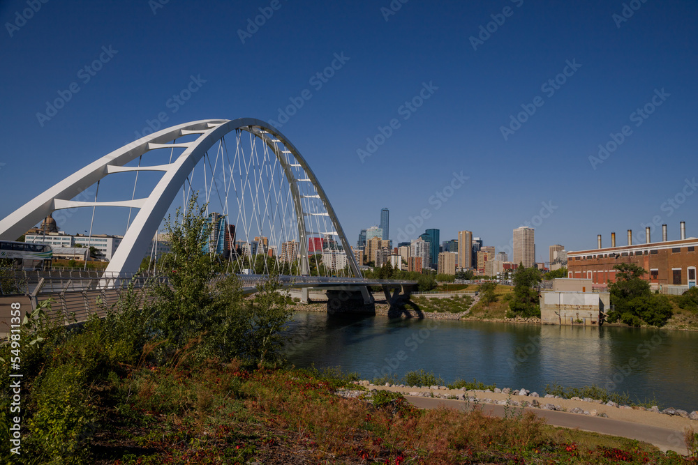 Modern arc bridge over the river, day traffic, summer time. modern architecture, panorama of the city Edmonton Modern arc bridge over the river, day traffic, summer time. modern architecture, panorama of the city Edmonton