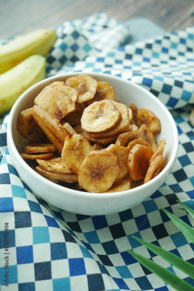 Close up of dried banana chips in a bowl on table . Close up of dried banana chips in a bowl on table .