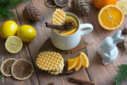 Aromatic tea with orange and spices on a wooden table. Pie  lemons  oranges winter mood.