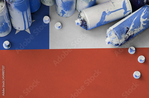 Chile flag and few used aerosol spray cans for graffiti painting. Street art culture concept photo