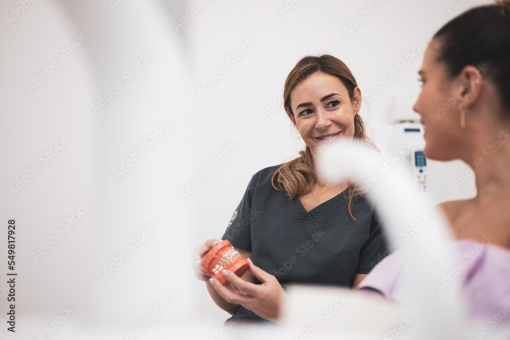 The Woman Dentist Shows Dentures With A Bracket In Her Hands False The Woman Dentist Shows Dentures With A Bracket In Her Hands False