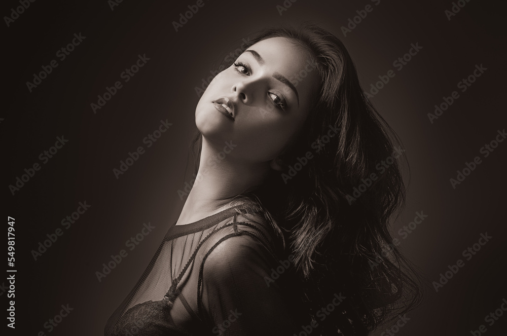 Monochrome portrait of a brunette on a black background. Young model girl posing in studio. Monochrome portrait of a brunette on a black background. Young model girl posing in studio.