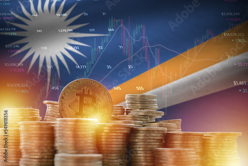 Marshall Islands flag and big amount of golden bitcoin coins and trading platform chart. Crypto currency photo