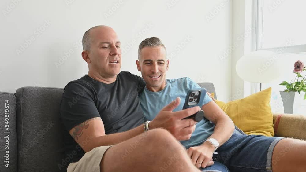 Male couple couch video call smart device Male couple couch video call smart device