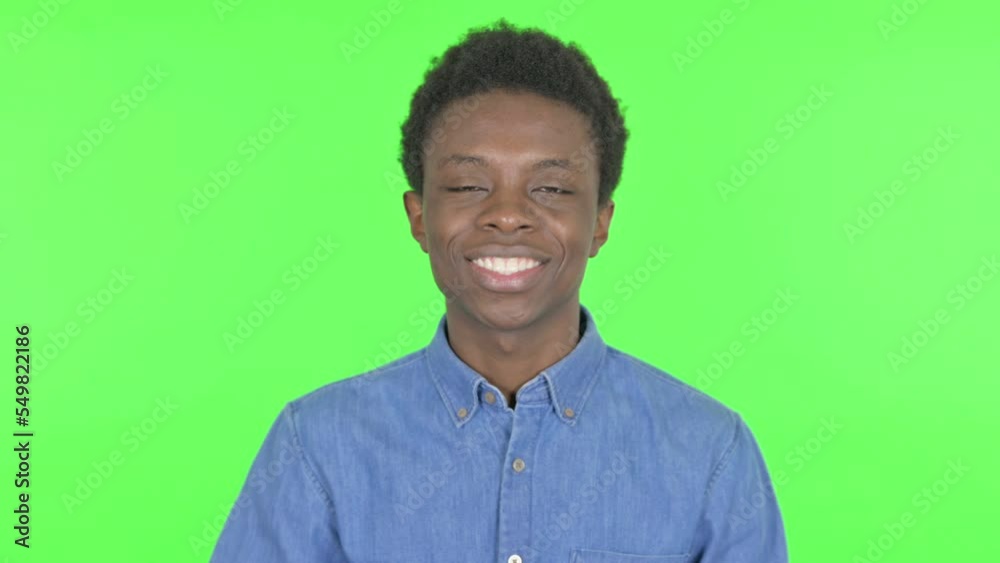 Young African Man Waving Hand to Say Hello on Green Background Young African Man Waving Hand to Say Hello on Green Background