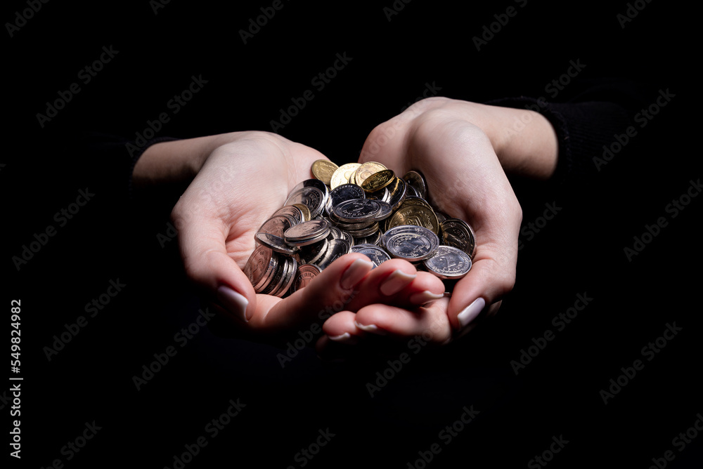 hands holding coins selective and soft focus isolated on black background with copy space.