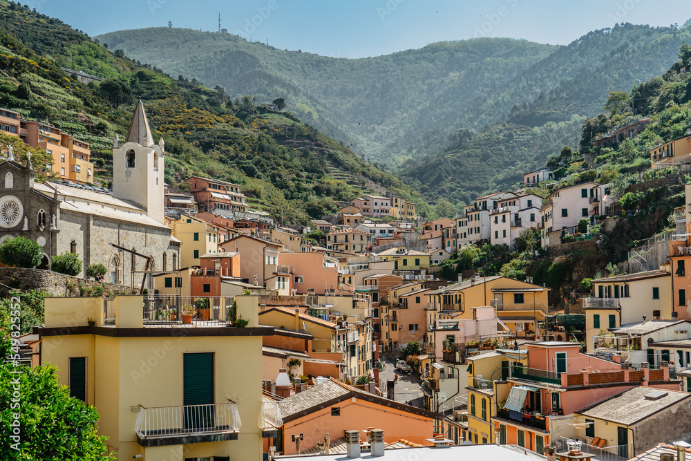 View of Riomaggiore,Cinque Terre,Italy.UNESCO Heritage Site.Picturesque colorful village on rock above sea.Summer holiday,travel background.Italian Riviera landscape.Houses on cliffs,vineyards around