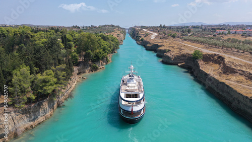 Aerial drone photo of yacht crossing narrow Corinth canal of Isthmus from West submersible bridge and narrow opening of Corinthian gulf to Saronic gulf, Loutraki, Greece