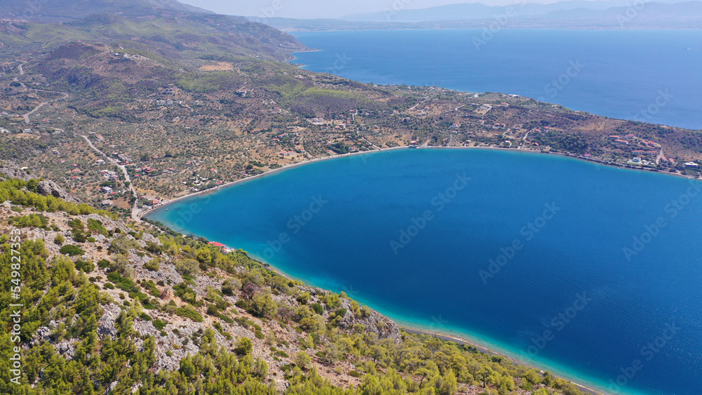 Aerial drone photo of scenic lake Vouliagmeni in Corinthia near famous lighthouse of Heraion and city of Loutraki featuring crystal clear turquoise beach and calm waters, Perachora, Greece