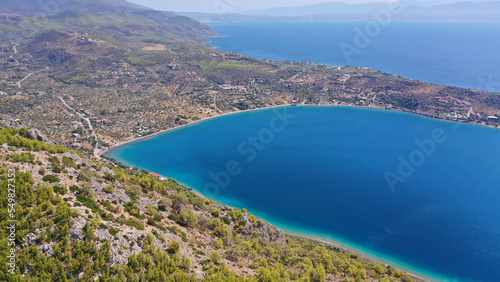 Aerial drone photo of scenic lake Vouliagmeni in Corinthia near famous lighthouse of Heraion and city of Loutraki featuring crystal clear turquoise beach and calm waters, Perachora, Greece