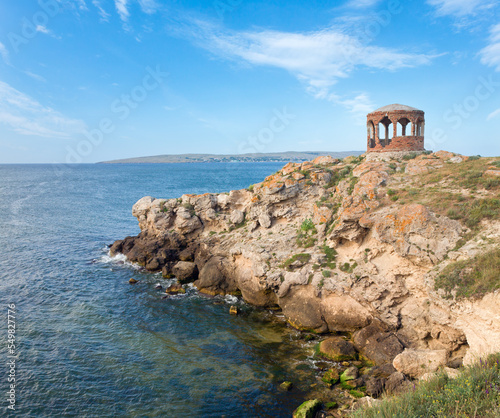 Rocky summer coastline and cape with pavilion