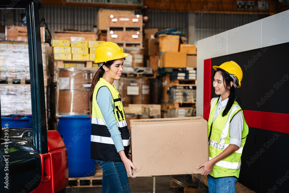 Warehouse worker holding box in a warehouse or storehouse.