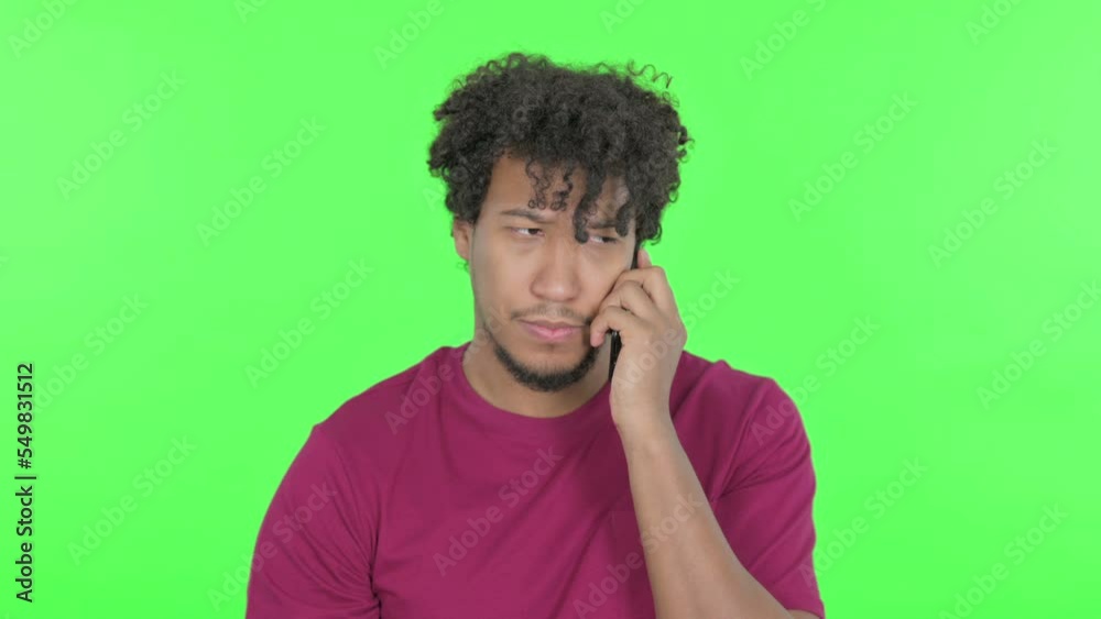 African Man Talking on Phone on Green Background African Man Talking on Phone on Green Background