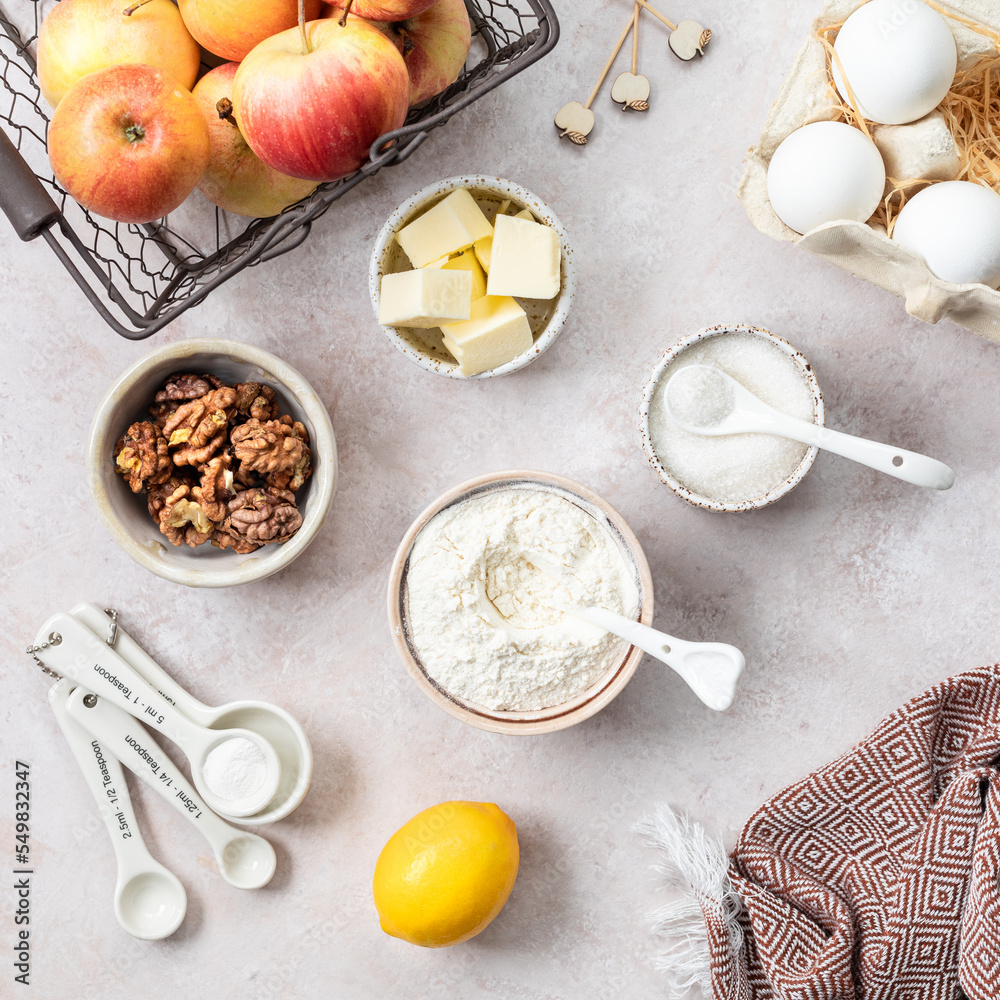 Ingredients for a sweet apple pie on a stone light background. View from above. Ingredients for a sweet apple pie on a stone light background. View from above.