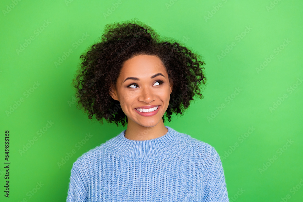 Photo of pretty lovely girlish woman with perming coiffure wear blue sweater looking at empty space isolated on green color background Photo of pretty lovely girlish woman with perming coiffure wear blue sweater looking at empty space isolated on green color background