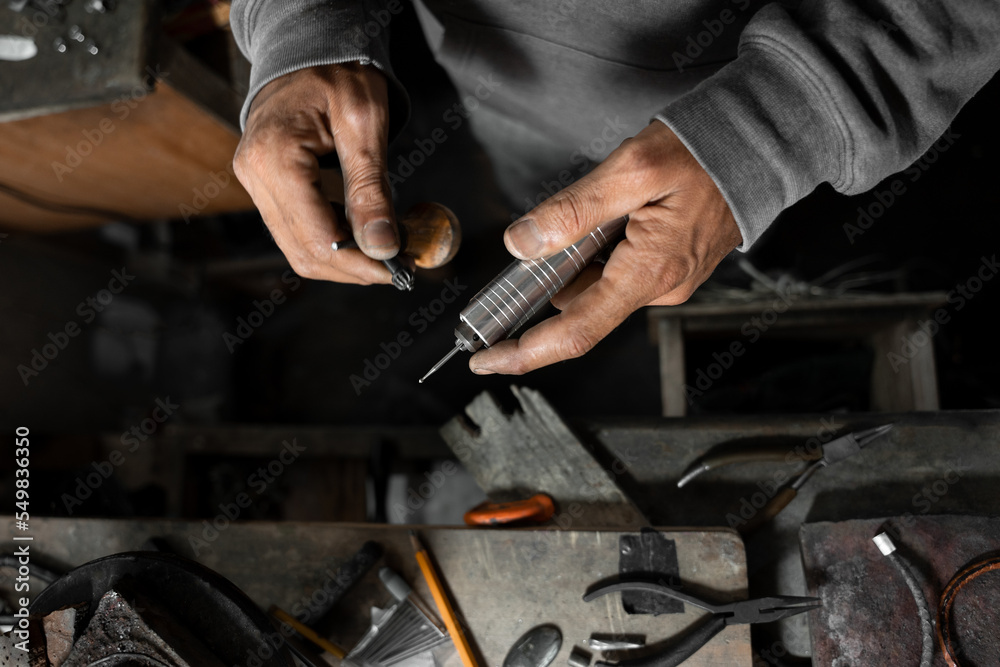 A craftsman jeweler is adjusting the drill to craft a jewel A craftsman jeweler is adjusting the drill to craft a jewel