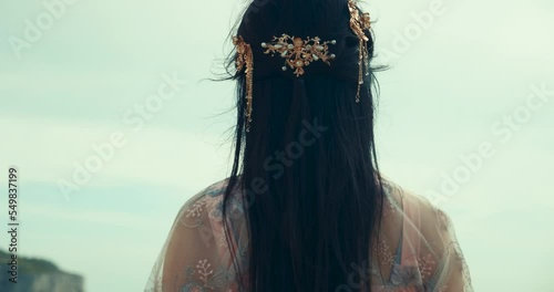Chinese Girl Stares at Landscape Above Cliff