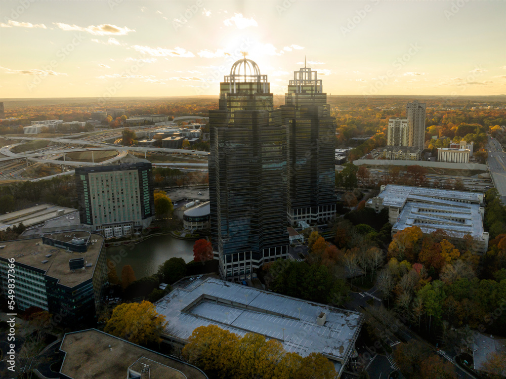 Aerial view of commercial buildings in Atlanta Metro Area with sun rays during sunset - obrazy, fototapety, plakaty 