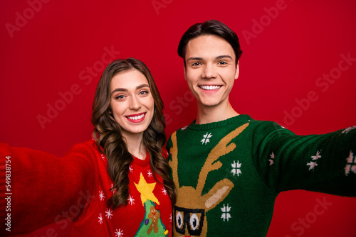 Photo of two cheerful funny people make selfie recording video toothy smile isolated on red color background