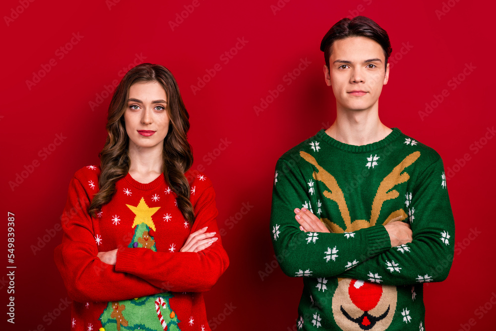 Portrait of two concentrated focused people folded hands calm face isolated on red color background Portrait of two concentrated focused people folded hands calm face isolated on red color background