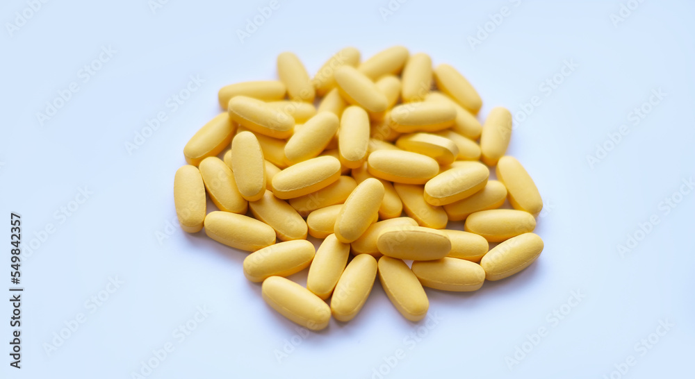 Close-up texture of yellow multivitamin tablets on white background. Healthy lifestyle concept Close-up texture of yellow multivitamin tablets on white background. Healthy lifestyle concept