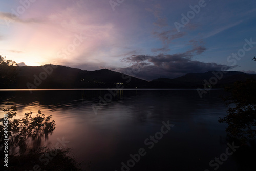 Guavio reservoir dam sunset landscape with gachala town mountains silhouette and water silk effect