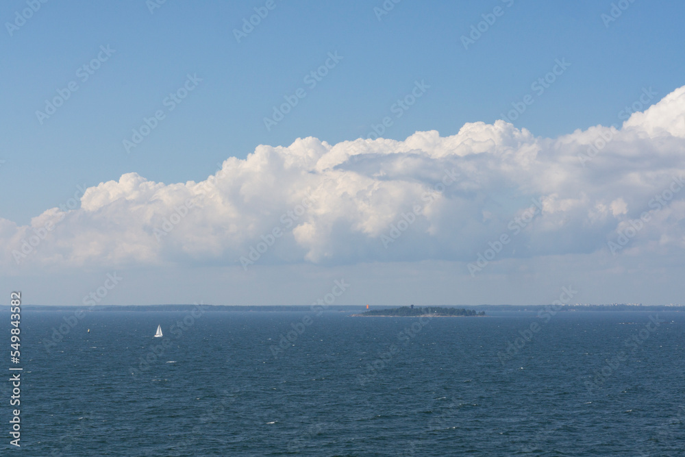 small island with a small vessel boat at finland golp open sea in sunny day